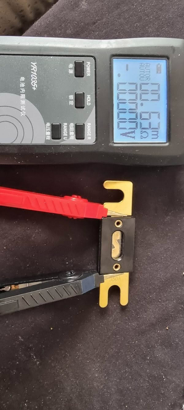 A digital caliper shows 10.59 mm as red and black electrical probes connect to a CNL Fibre Glass Fuse, which appears to be an electrical connector, resting on a dark surface.