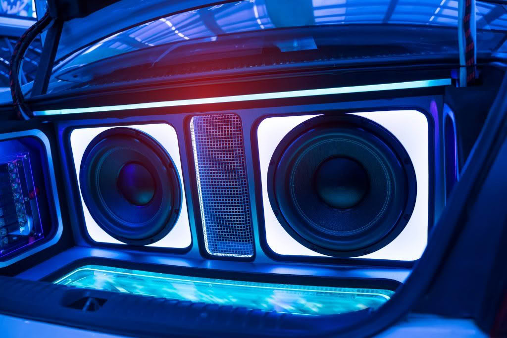Car trunk with illuminated subwoofers and speakers.