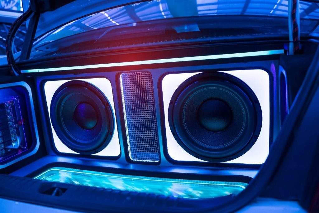 Car trunk with illuminated subwoofers and speakers.