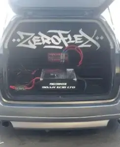 Car trunk audio system with amplifiers and cables.