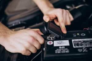 Person checking car battery connections.