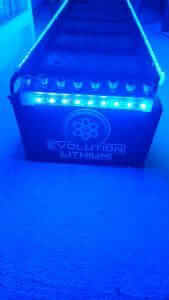 Blue-lit Evolution Lithium battery on carpet.