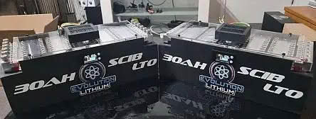 Two large lithium battery packs with labels displaying specifications and branding